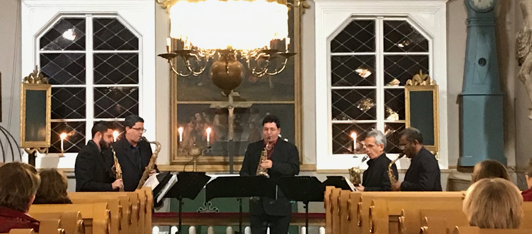 Viisi miestä soittavat saksofoneja kirkossa